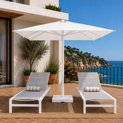 Two lounge chairs under a large white umbrella on a deck with ocean view