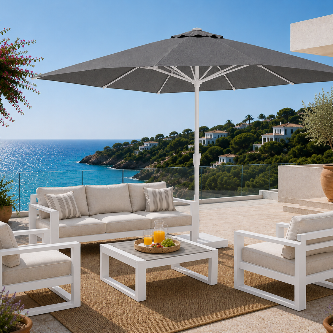 Outdoor patio set with a large umbrella overlooking a scenic ocean view.