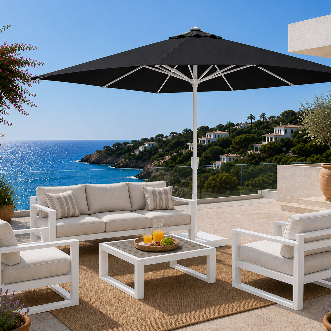 Outdoor patio set with a black umbrella, white furniture, and ocean view.